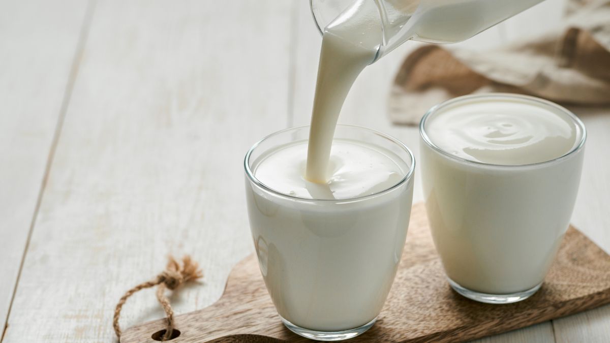 Kefir öntése egy pohárba, friss és krémes állagú tejtermék.