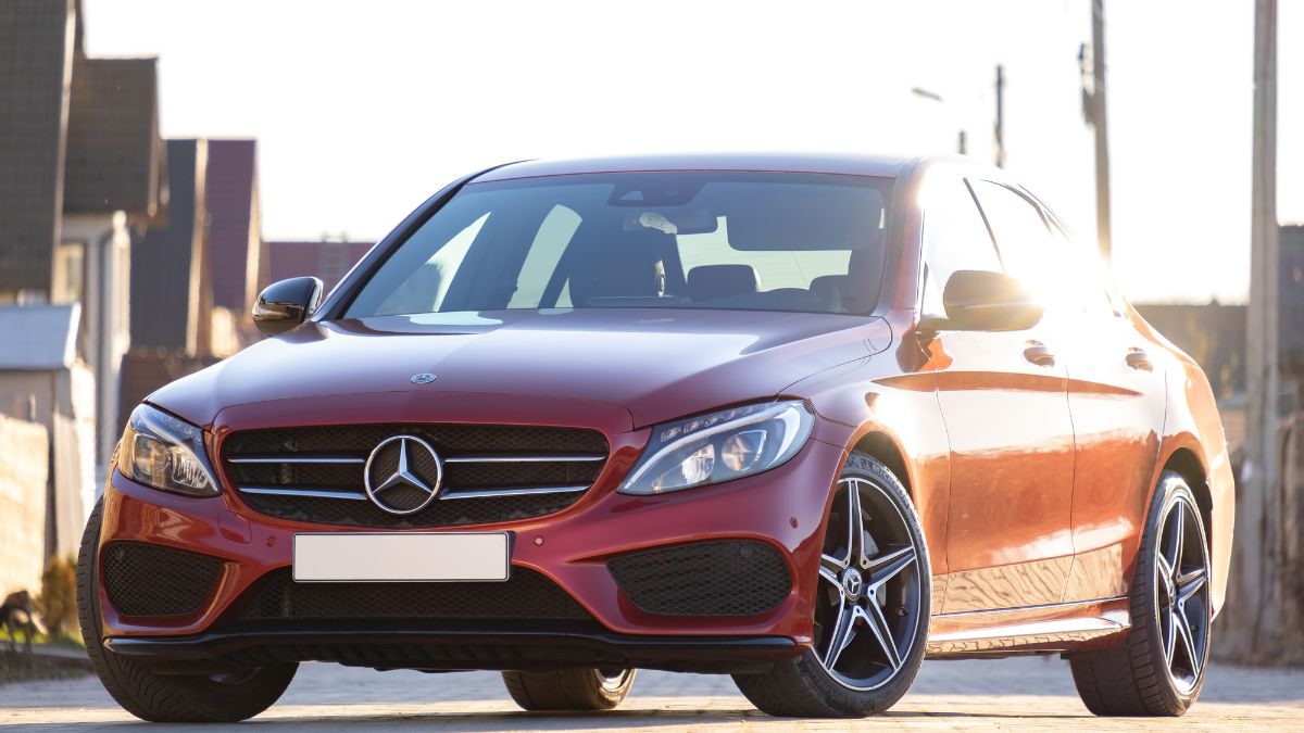 Egy piros Mercedes autó, sportos dizájnnal, napfényben áll.