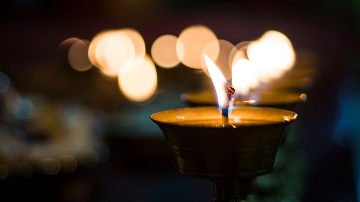 Egy égő gyertya lángja, amely a spiritualitás és a meditáció szimbóluma.
